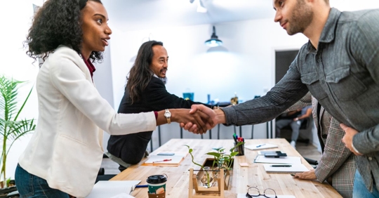 people shaking hands at negotiation table